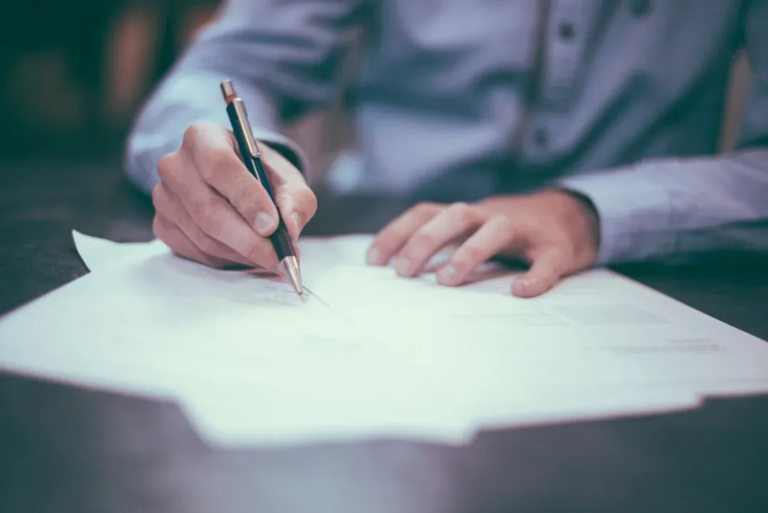 expat signing a contract, two people shaking hands